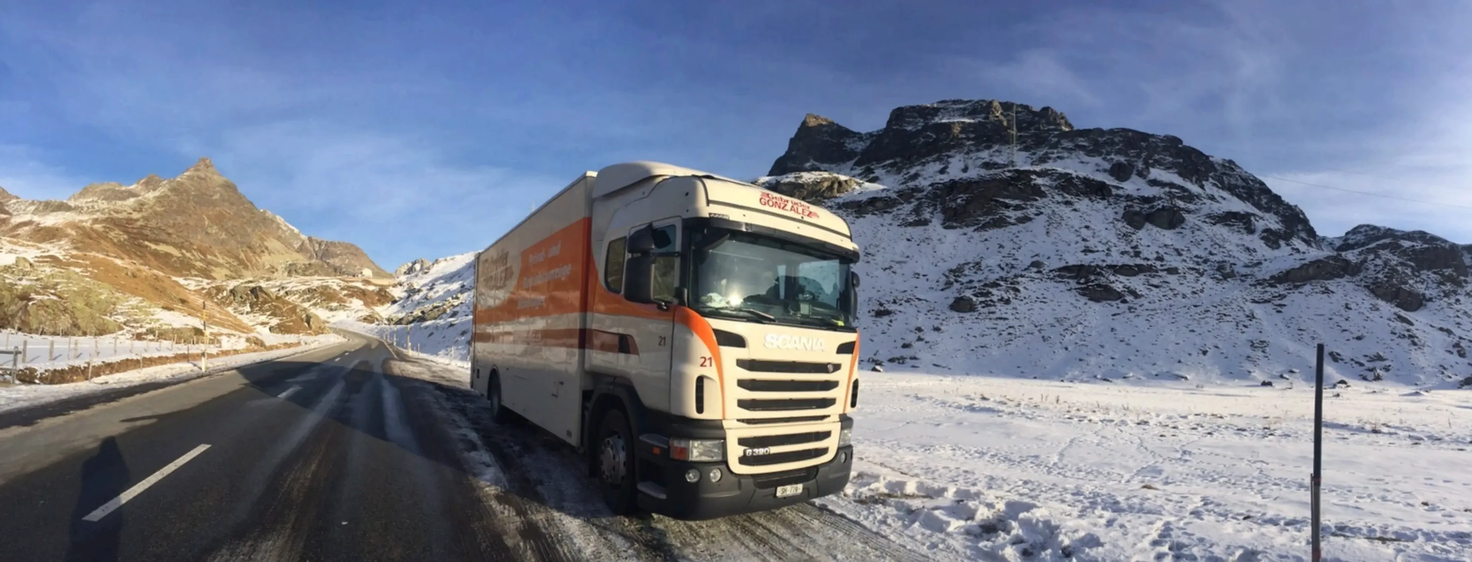 Umzugswagen der Gebrüder GONZALEZ AG auf einem verschneiten Alpenpass